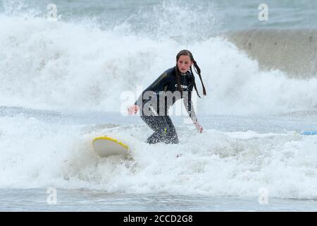 Portreath, Cornwall, Royaume-Uni. 21 août 2020. Météo Royaume-Uni. Un surfeur aime monter sur les vagues fouettées par Storm Ellen à Portreath, dans les Cornouailles, lors d'une journée de vents violents et de soleil brumeux. Crédit photo : Graham Hunt/Alamy Live News Banque D'Images