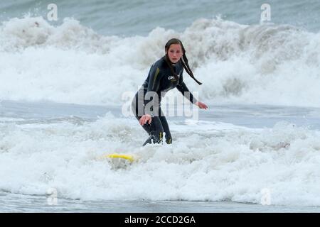 Portreath, Cornwall, Royaume-Uni. 21 août 2020. Météo Royaume-Uni. Un surfeur aime monter sur les vagues fouettées par Storm Ellen à Portreath, dans les Cornouailles, lors d'une journée de vents violents et de soleil brumeux. Crédit photo : Graham Hunt/Alamy Live News Banque D'Images