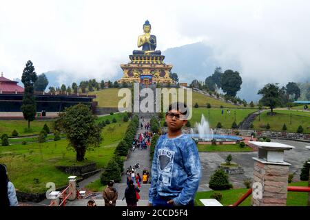 Un jeune garçon indien posant pour la photo devant la statue de Bouddha de Ravangla Parc de Sikkim, la focalisation sélective Banque D'Images