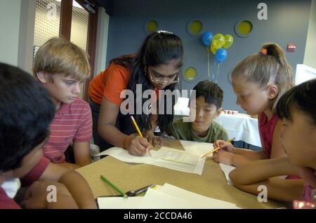 Les enfants travaillent sur un projet de chute d'œuf lors d'une « journée de travail à emporter » dans un bureau d'entreprise. La tâche enseigne aux enfants la gestion de projet sur le lieu de travail. ©Bob Daemmrich Banque D'Images