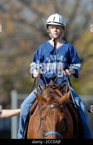 Austin, Texas 13 décembre 2006 : un étudiant de neuvième année qui fréquente la Texas School for the Blind and visuellement Malvoyants (TSVBI) fait l'expérience de l'équitation pour la première fois lors d'une sortie à l'école du centre d'Austin. Les éleveurs de la région apportent des chevaux sur le campus une fois par an pour offrir de nouvelles expériences et aider à établir la confiance en soi pour les étudiants aveugles légalement. ©Bob Daemmrich Banque D'Images