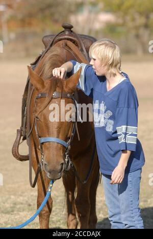 Austin, Texas 13 décembre 2006 : un étudiant de neuvième année qui fréquente la Texas School for the Blind and visuellement Malvoyants (TSVBI) fait l'expérience de l'équitation pour la première fois lors d'une sortie à l'école du centre d'Austin. Les éleveurs de la région apportent des chevaux sur le campus une fois par an pour offrir de nouvelles expériences et aider à établir la confiance en soi pour les étudiants aveugles légalement. ©Bob Daemmrich Banque D'Images