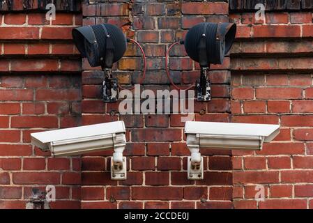 Deux caméras de surveillance sur un mur de briques rouges, avec spots infrarouges Banque D'Images