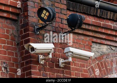 Deux caméras de surveillance sur un mur de briques rouges, avec spots infrarouges Banque D'Images