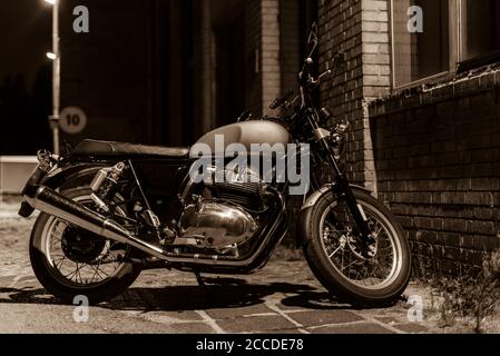 Une moto la nuit, une moto se tient sous une lumière de rue, un croiseur, une moto d'époque, une photo en noir et blanc Banque D'Images