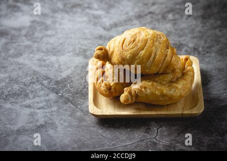 Pâte feuilletée au curry sur fond de béton. Banque D'Images