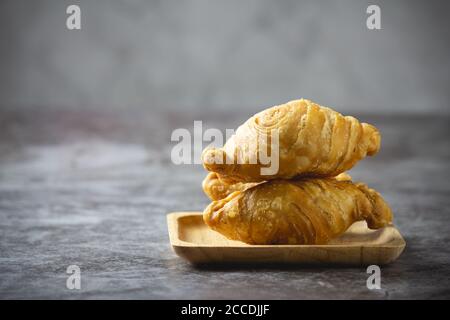 Pâte feuilletée au curry sur fond de béton. Banque D'Images