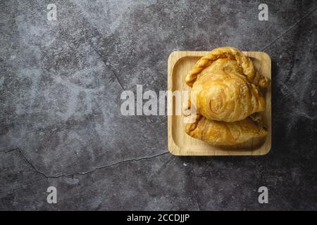 Pâte feuilletée au curry sur fond de béton. Banque D'Images