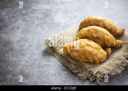 Pâte feuilletée au curry sur fond de béton. Banque D'Images