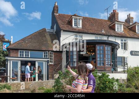 Visiteurs prenant des selfies au pub Crown and Anchor de Dell Quay, Chichester Harbour, West Sussex, Royaume-Uni Banque D'Images