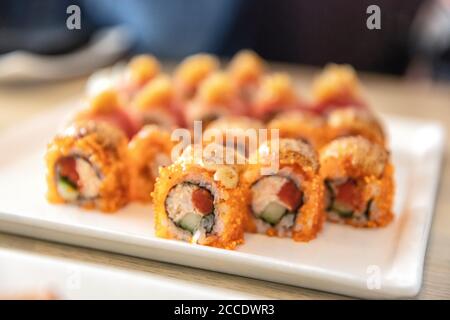 Un petit sushi de thon maguro recouvert de saumon roé dans un luxueux restaurant japonais haut de gamme. Plaque de sushis. Banque D'Images