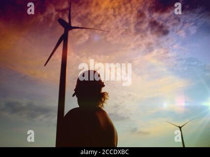 Ingénieur dans une éolienne. Une femme dans un casque supervise le fonctionnement des moulins à vent électriques. Concept de l'écologie et des sources d'énergie renouvelables. Banque D'Images