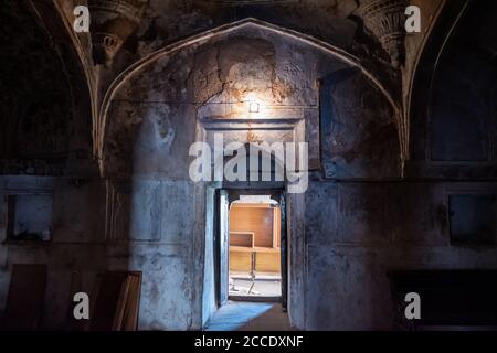 Orcha, Madhya Pradesh, Inde - Mars 2019: Une porte voûtée d'une salle sombre avec des murs rouillés à l'intérieur de l'ancien palais Jehangir Mahal dans l'Orcha F. Banque D'Images