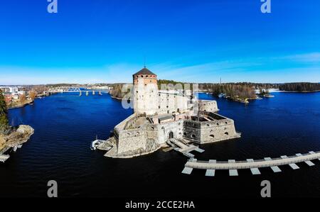 Belle vue aérienne d'Olavinlinna, ancienne forteresse d'Olofsborg, le château médiéval de trois tours du XVe siècle situé dans la ville de Savonlinna sur un soleil Banque D'Images