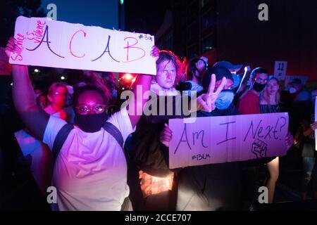 Tulsa, OK, États-Unis. 20 juin 2020 : Black Lives Matters des manifestants se tiennent devant des policiers et des véhicules de la Garde nationale qui quittent le centre-ville de Tulsa après un rassemblement de Donald Trump. Banque D'Images