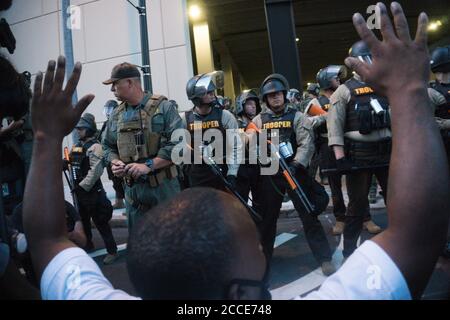 Tulsa, OK, États-Unis. 20 juin 2020 : UN manifestant tient les mains en s'agenouillant devant les policiers après avoir arrêté un homme dans le centre-ville de Tulsa. Banque D'Images