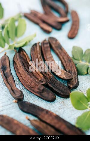 Caroubes sur une table en bois. Banque D'Images