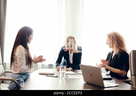 concept d'entreprise des femmes. Une jeune femme blonde signe des documents pour fournir une aide active au développement des initiatives d'affaires des femmes. Banque D'Images