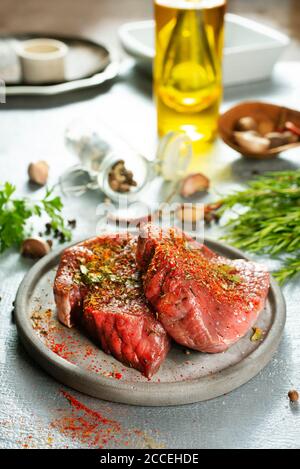 Viande crue bœuf steak bio ingrédient frais sur l'assiette grise Banque D'Images