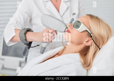 jeune client blond décontracté recevant une épilation au laser. gros plan sur une photo de vue latérale Banque D'Images