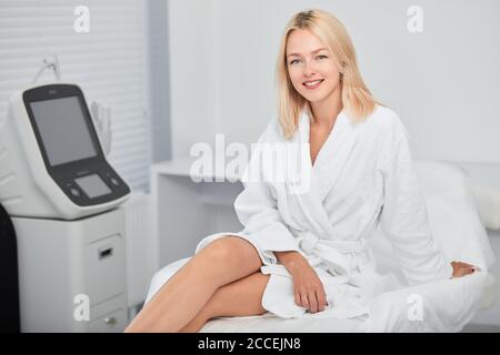 gaie positive femme en peignoir blanc appréciant sa journée de repos, femme d'affaires a un repos à l'intérieur Banque D'Images