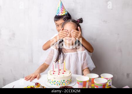 petit garçon beau couvrant les yeux de la fille avec les mains. gros plan photo.surprise pour petite sœur. amour Banque D'Images