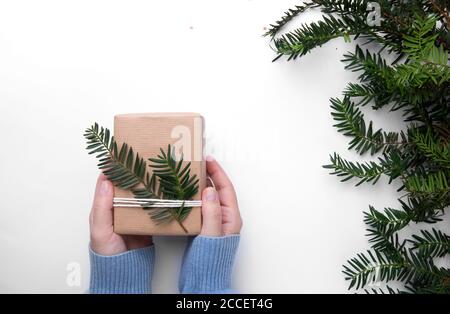Les mains dans un chandail bleu tiennent le cadeau fait main Banque D'Images