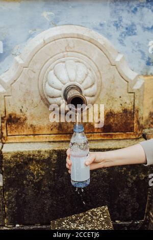 Femme remplissant une bouteille en plastique avec de l'eau de source Banque D'Images