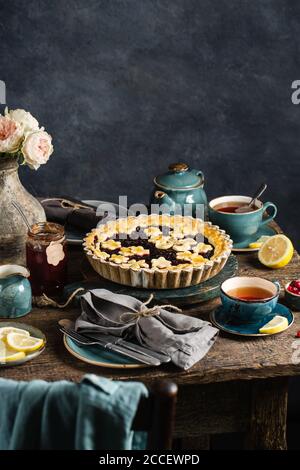 Fête du thé à la table d'automne avec une tarte aux baies et une tasse de thé chaud. Banque D'Images