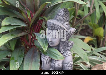 Statue dans les plantes Banque D'Images