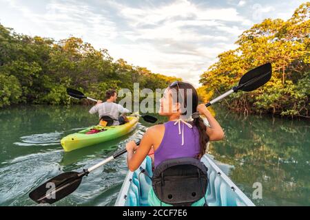 Couple kayak ensemble dans la rivière de mangrove des Keys, Floride, États-Unis. Touristes kayakistes visitant la rivière de l'Islamorada Banque D'Images