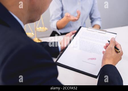 Client avec ses avocats partenaires ou avocats discutant de discuter d'un document ou d'un contrat de travail à table dans le bureau, bon service cooperati Banque D'Images