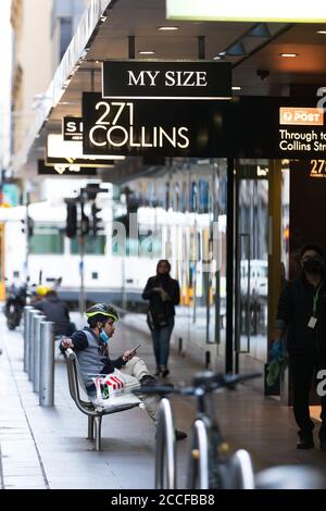 Un homme est assis sur un banc dans le CBD pendant la COVID-19 à Melbourne, en Australie. La quarantaine à l'hôtel a été liée à 99 % des cas COVID-19 de Victoria, a-t-on appris. T Banque D'Images