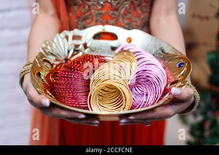 Une personne tenant dans une grande plaque, multi couleur bracelets indiens Banque D'Images