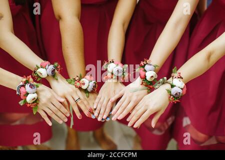 Vue de la demoiselle d'honneur avec des bouquets de fleurs attachés sur leur poignets Banque D'Images