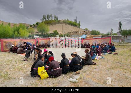 Mulbekh, Ladakh, Inde - 2 septembre 2014 : les ladakhi en robes traditionnelles, réunis pour un festival religieux. Montagnes de l'Himalaya en toile de fond. Banque D'Images