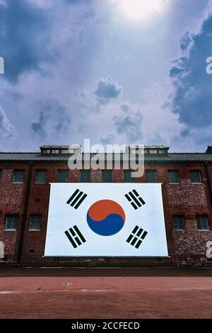 Un immense drapeau coréen sur un mur de briques dans un matin nuageux avec un faisceau lumineux. Séoul, Corée. Banque D'Images