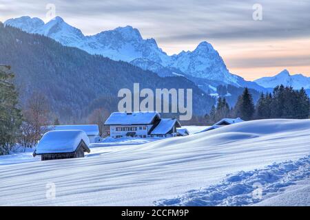Maisons enneigées contre le groupe Zugspitze (2962 m) dans les montagnes de Wetterstein, hameau Gerold BEI Klais, district de Krün, Werdenfelser Land, Upper Banque D'Images