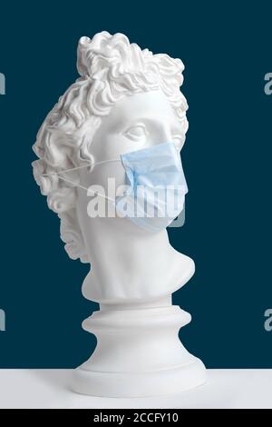 Statue de gypse de la tête d'Apollo dans un masque médical. Appel vidéo. Auto-isolation. Vidéoconférence. Événement virtuel. Masque. Coronavirus. Épidémie. Banque D'Images