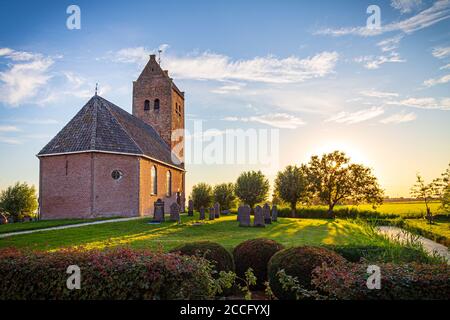 Église protestante hollandaise typique appelée Bartholomeuskerk au coucher du soleil à Westhem en Frise, pays-Bas, Europe Banque D'Images