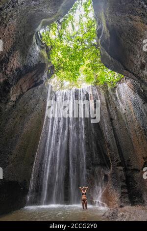 Tukad Cepung Waterfall est une magnifique cascade dans un petit système de grottes et est une attraction touristique populaire à Bali. Les arbres de lumière et l'eau s Banque D'Images