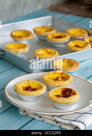 tarte aux œufs au dessert ou crème anglaise douce à l'œuf du portugal sur plat blanc et table en bois bleu Banque D'Images