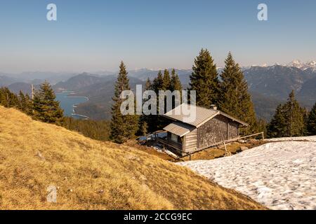 Cabane de la garde de montagne sur le Simetsberg avec un peu de neige ancienne, en arrière-plan le Karwendel et le Walchensee Banque D'Images