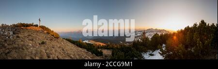 Panorama depuis le coucher du soleil sur le Simetsberg avec un ciel bleu avec une croix de sommet et une vue sur la vallée de l'Isar, le Karwendel, les montagnes de Wetterstein et Banque D'Images