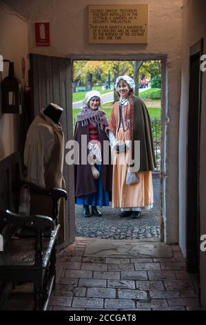 Captain Cook's Cottage en regardant la porte devant deux femmes en robe d'époque, une attraction touristique majeure dans Fitzroy Gardens Melbourne, Australie Banque D'Images