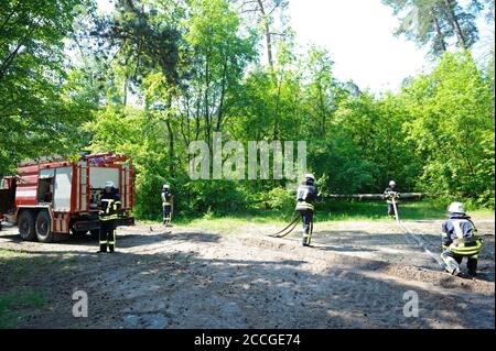 Moteur d'incendie stationné, équipe de pompiers préparant l'équipement de lutte contre l'incendie pour utilisation. 5 juin 2019. 2019.l'oblast de Kievskaya, Ukraine Banque D'Images