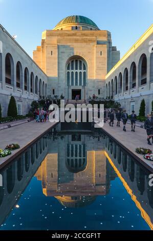 Vue sur la piscine de la cour, les réflexions des bâtiments et les groupes touristiques menant à la citadelle et au tombeau du soldat inconnu à Canberra, en Australie. Banque D'Images