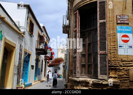 Les touristes marchant dans la rue étroite appelée Atilla à Girne avec le pointeur vers le château et le vieux port. Chypre du Nord. Banque D'Images