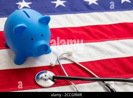 Coût de l'assurance maladie aux États-Unis. Stéthoscope médical et banc de porc sur un drapeau américain. Concept américain de budget de santé Banque D'Images