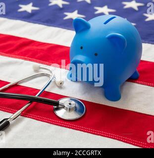 Coût de l'assurance maladie aux États-Unis. Stéthoscope médical et banc de porc sur un drapeau américain. Concept américain de budget de santé Banque D'Images